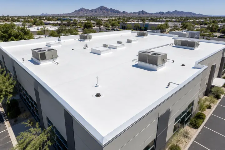 Finished new white commercial roof with new flashing, clean drains and HVAC curbs, aerial view